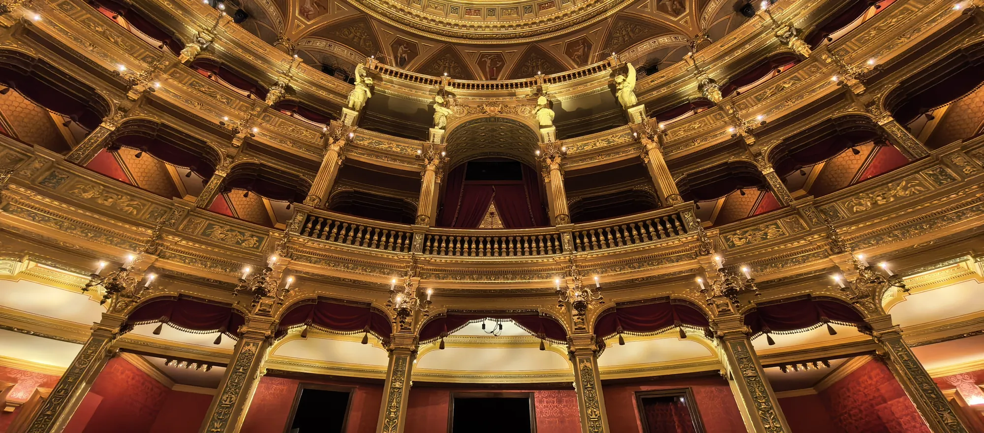 Tiers of gilded boxes with red velvet linings curving round the auditorium of the Hungarian State Opera House